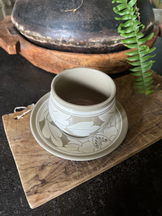 White and beige tea cup and saucer